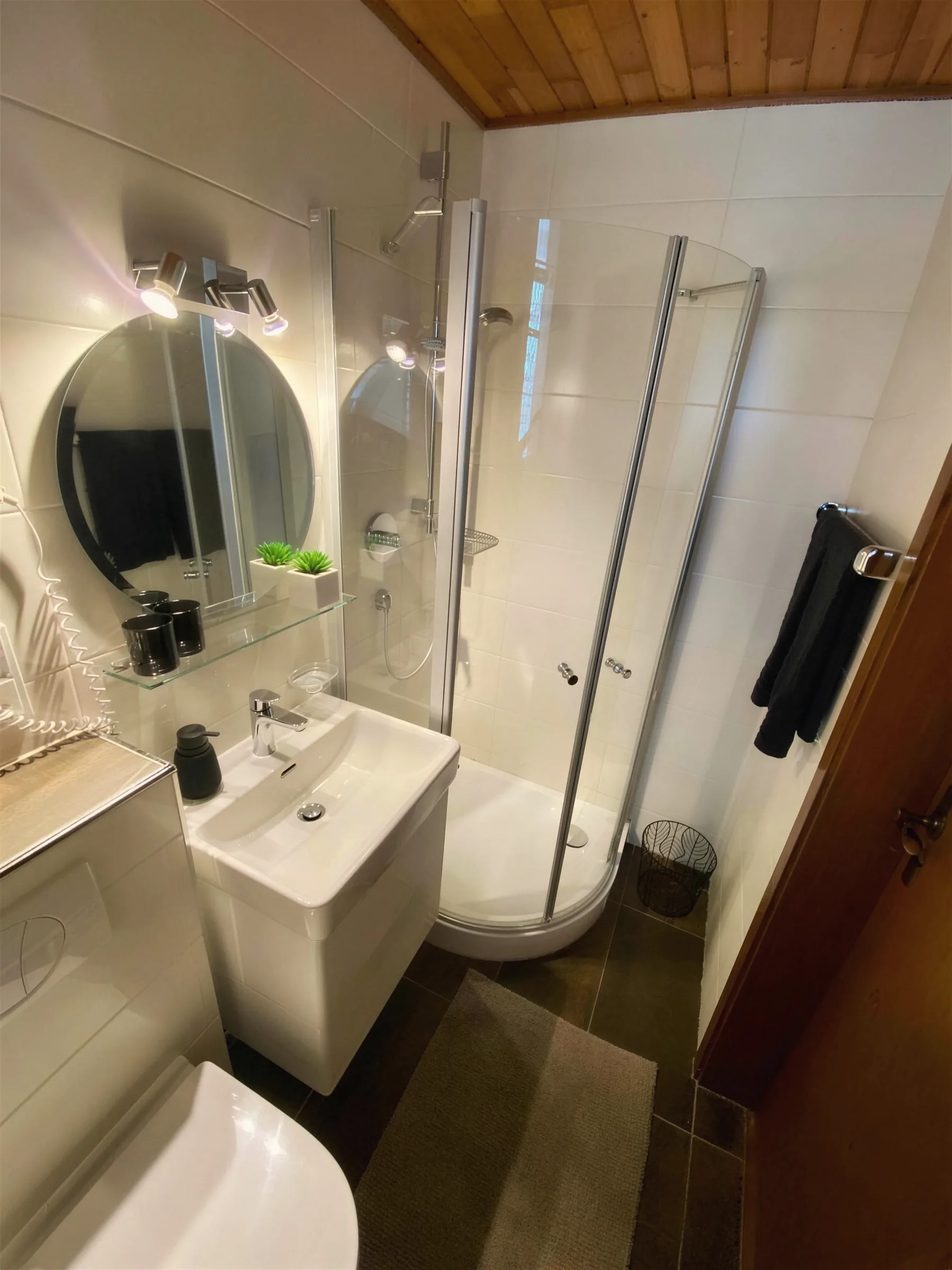 Helles Bad mit Dusche, Waschbecken und Spiegel