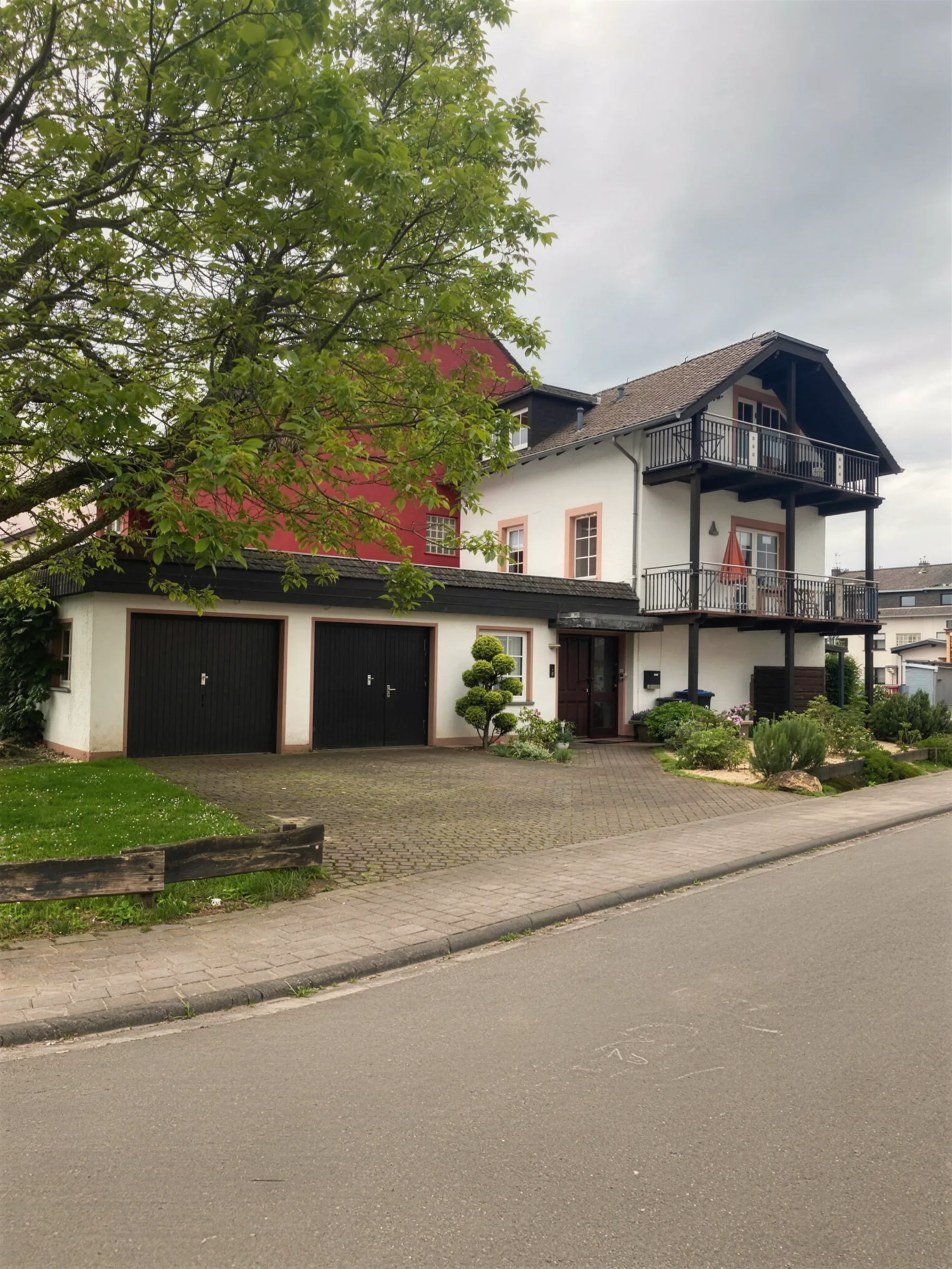 Das Haus an der Straße hinter dem großen Baum