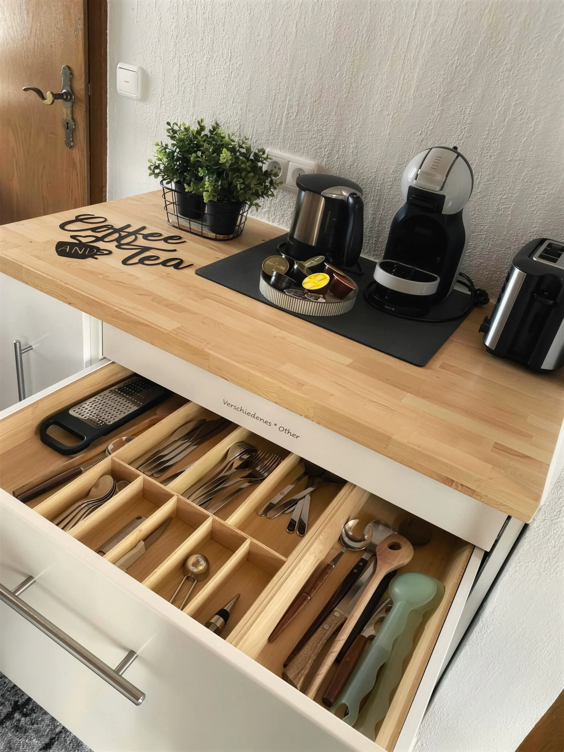 Geöffnete Küchenschubladen mit Besteck und Kaffee